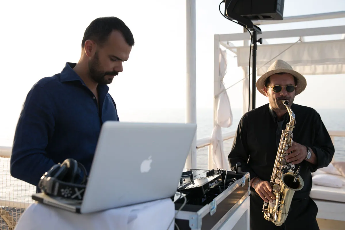 DJ e sassofonista al tramonto in una location vista mare